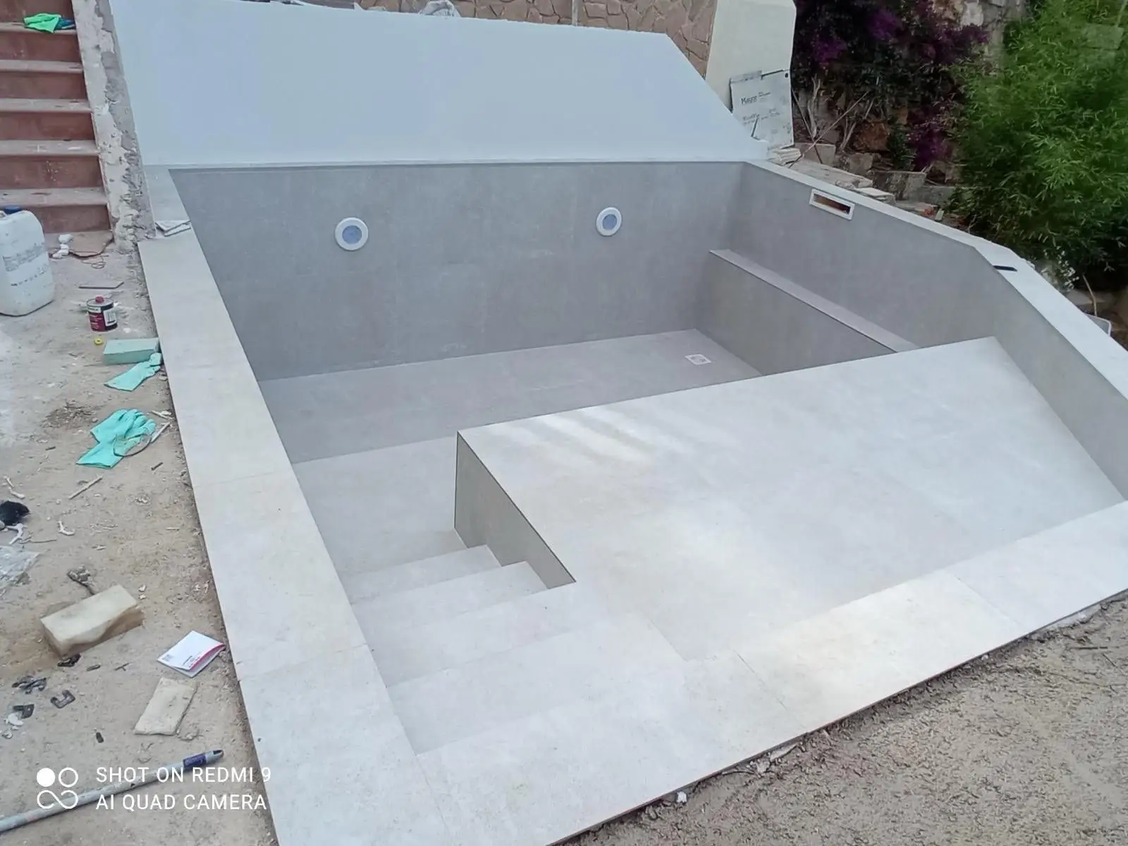 Construcción de piscina con revestimiento de gresite azul y escalera de obra en Mallorca