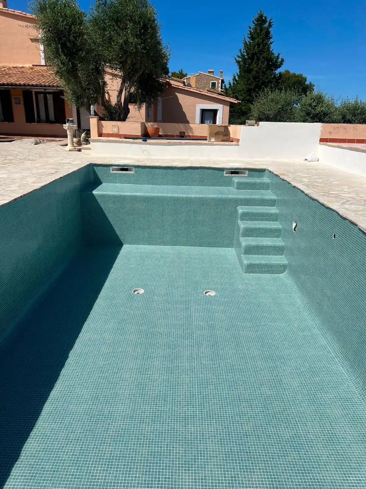 Piscina revestida con gresite verde turquesa y escalera de obra integrada en Palma