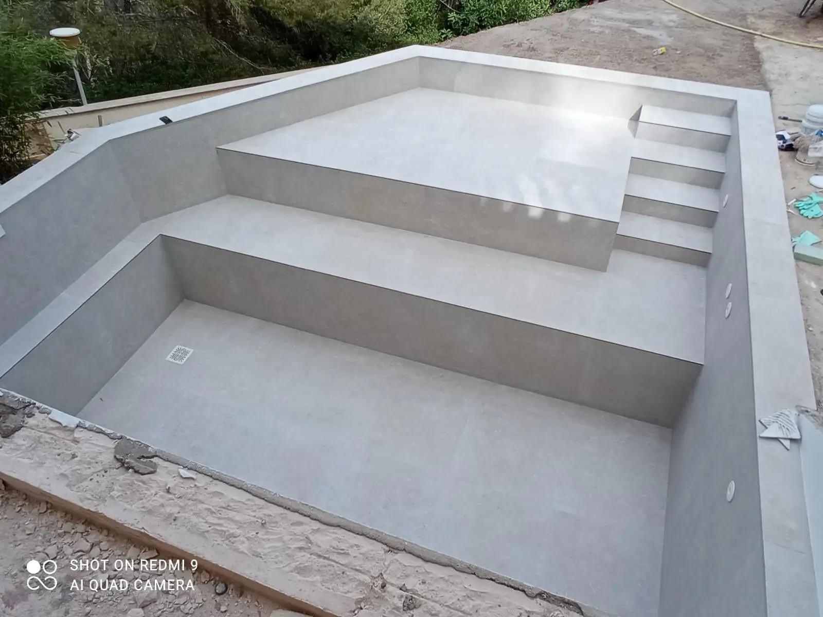 Construcción de piscina con revestimiento de gresite azul y escalera de obra en Mallorca